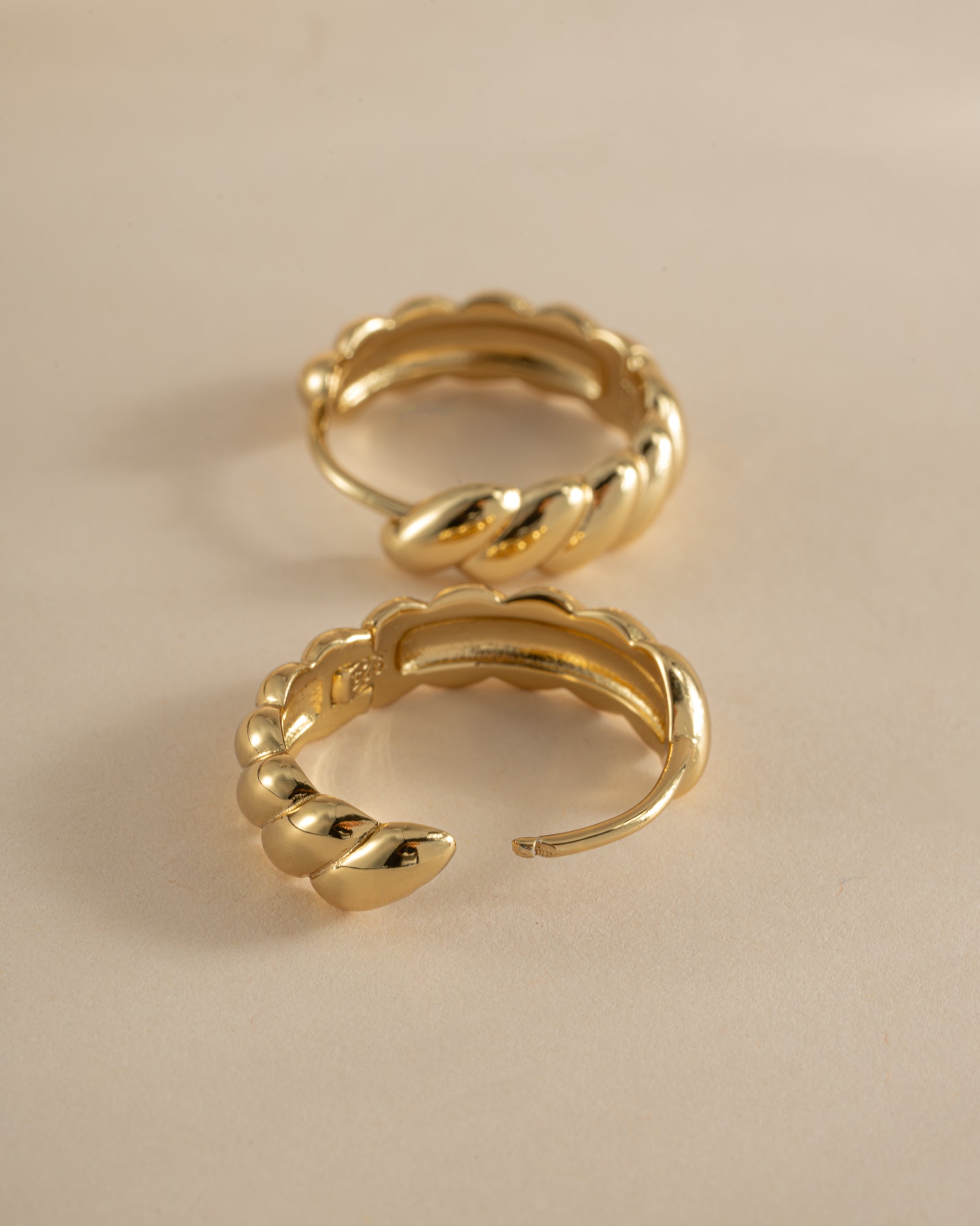 Gold croissant hoop earrings by Sami Jewels, showcasing stylish jewelry with a shiny, curved hoop design.
