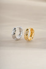 Gold and sterling silver croissant-shaped studded hoops earrings by Sami Jewels with textured, fashionable design.