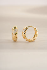 Gold studded croissant hoop earrings from Sami Jewels, angled view showcasing textured surface and hoop design.