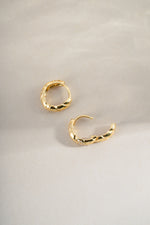 Sami Jewels studded croissant hoop earrings shown in side profile, featuring a textured croissant shape with metal studs.