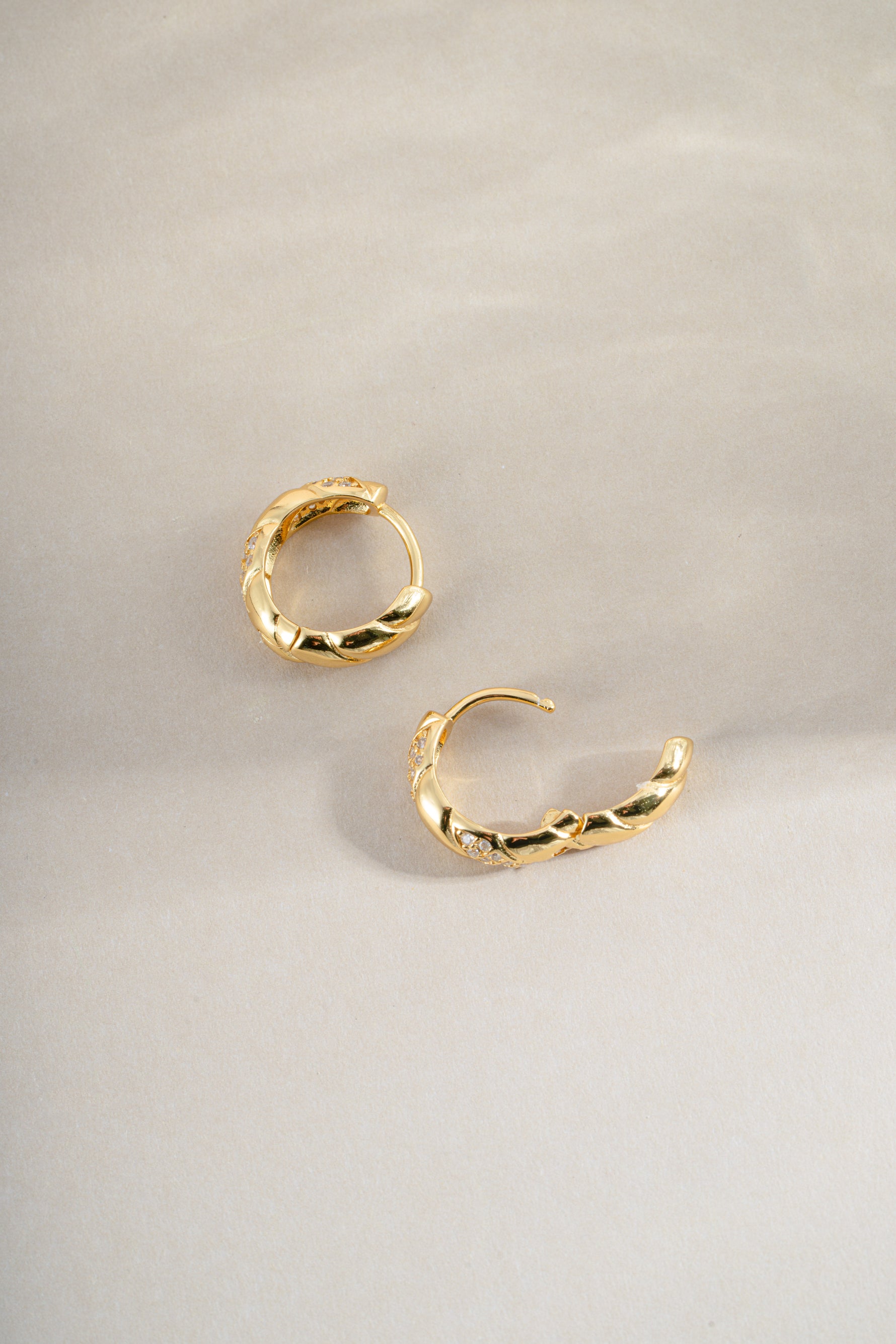 Sami Jewels studded croissant hoop earrings shown in side profile, featuring a textured croissant shape with metal studs.