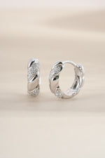 Sterling silver croissant-shaped studded hoop earrings by Sami Jewels featuring a textured, stylish design.
