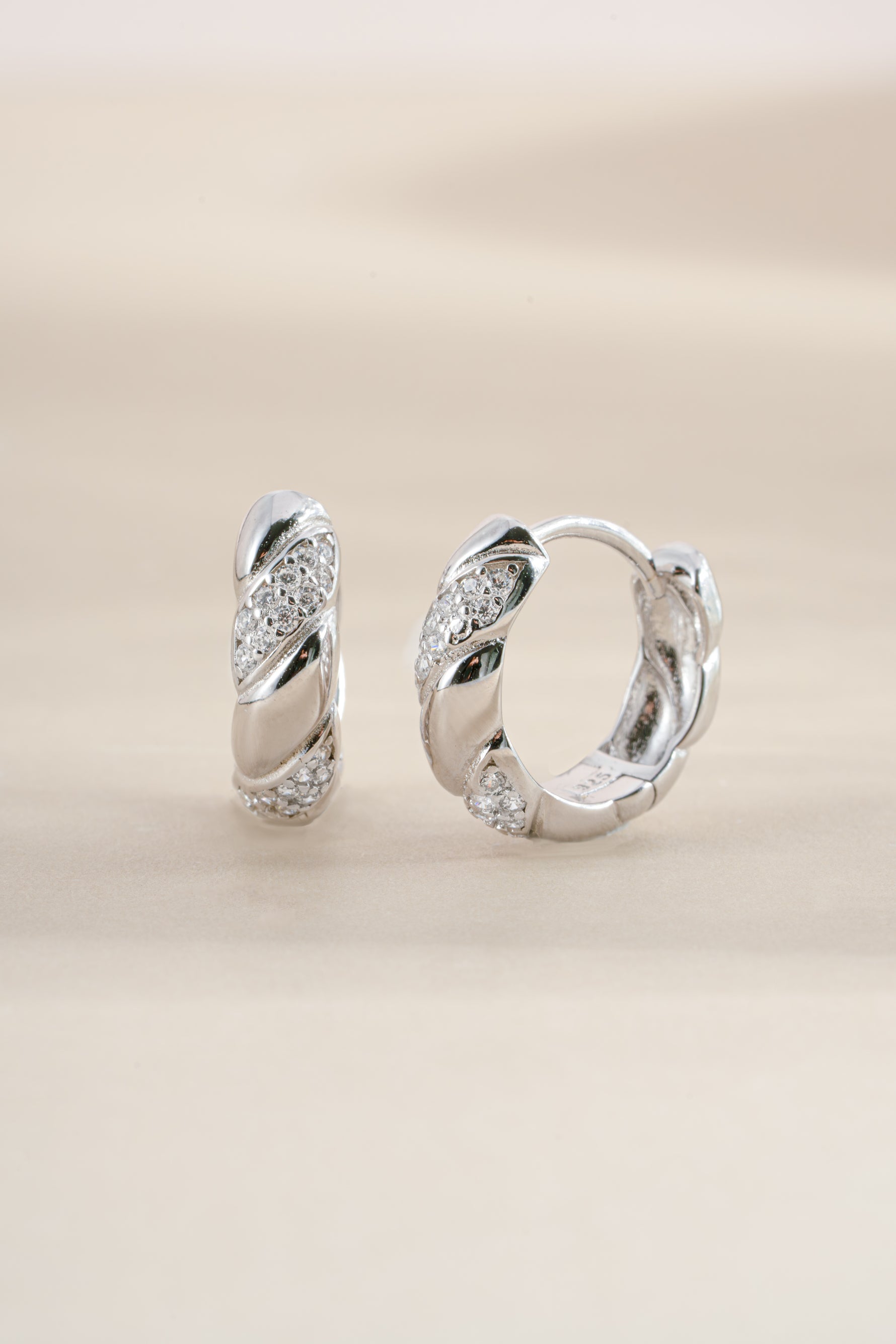 Sterling silver croissant-shaped studded hoop earrings by Sami Jewels featuring a textured, stylish design.