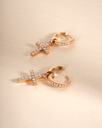 Rose gold CZ cross charm huggie earrings by Sami Jewels featuring small hoop earrings with cross pendants.