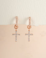 Rose gold CZ cross charm huggie earrings by Sami Jewels, featuring small hoop earrings with cross pendants.