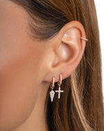 Rose gold Sami Jewels cross and dagger charm huggie earrings with detailed design, perfect for stylish everyday wear.
