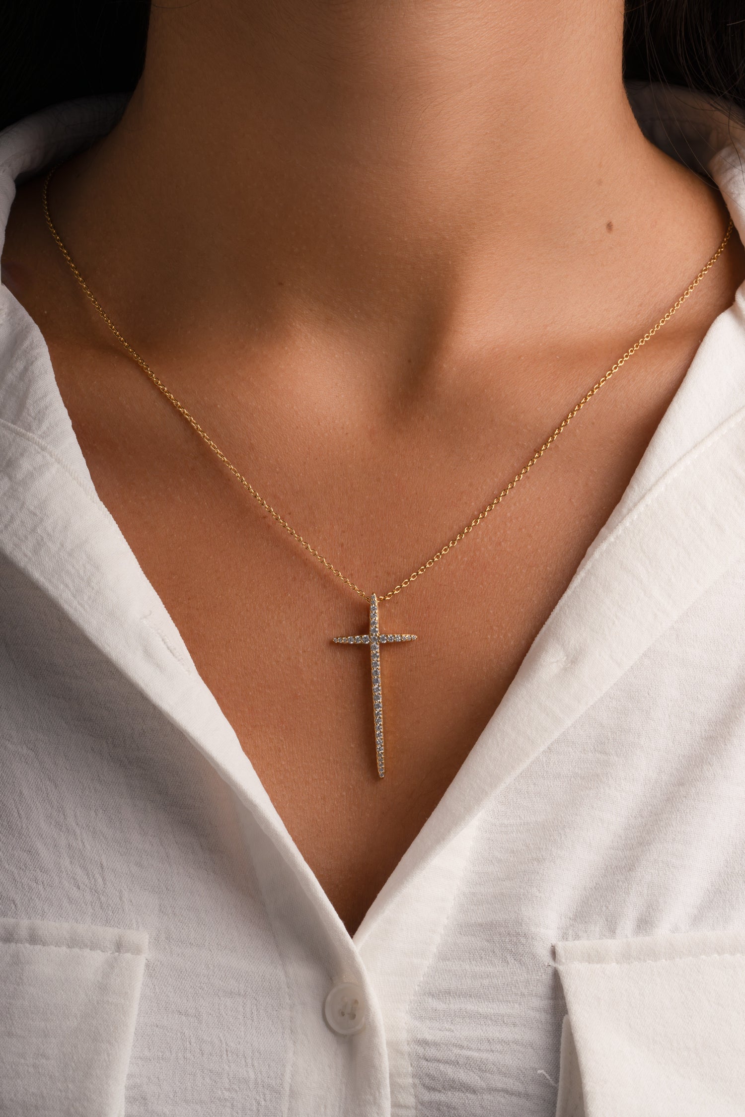 Gold cross necklace from Sami Jewels featuring a sleek design, worn by a model, perfect for layered or everyday wear.