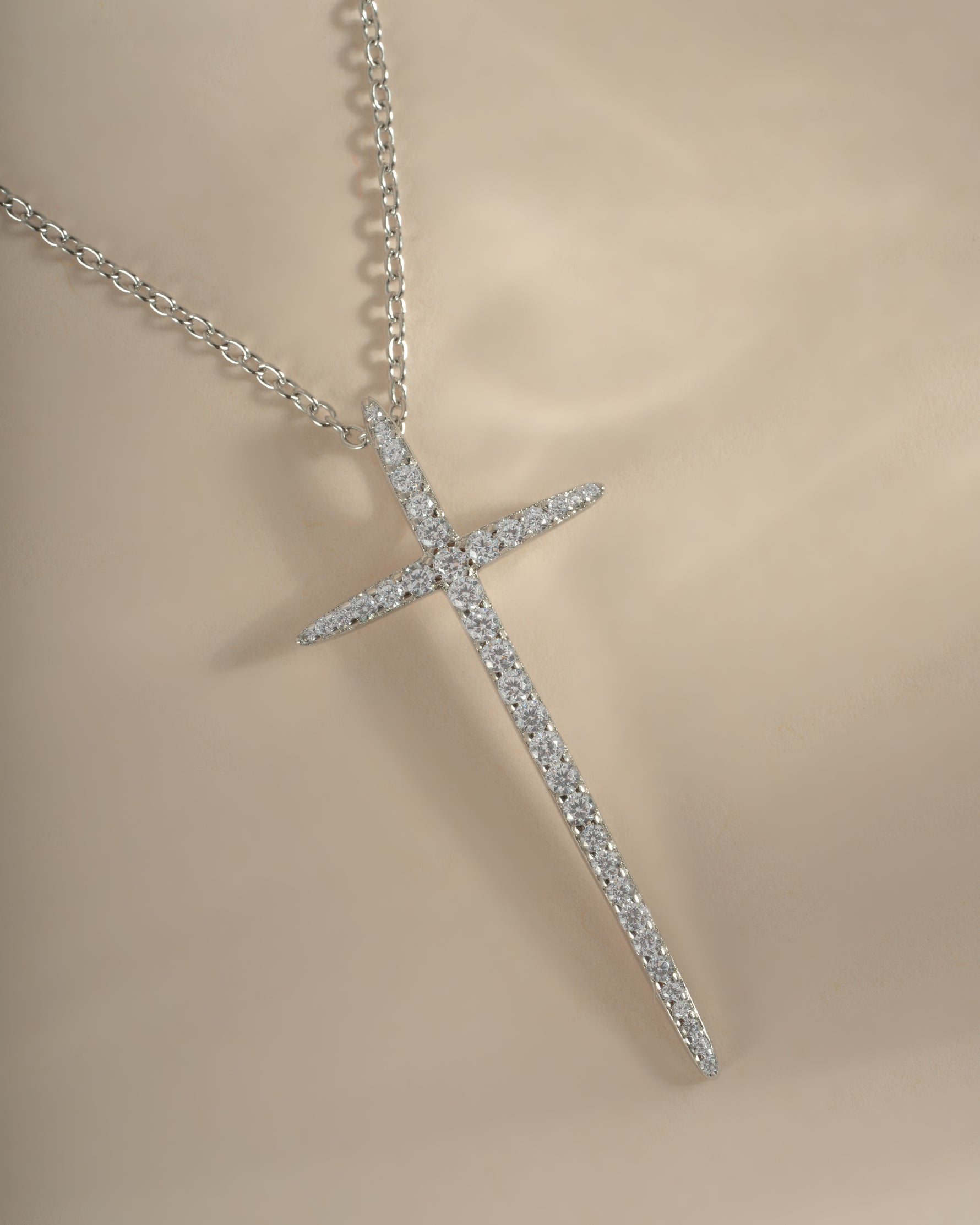 Sterling silver cross necklace by Sami Jewels, close-up showing detailed design and chain link on a plain background.