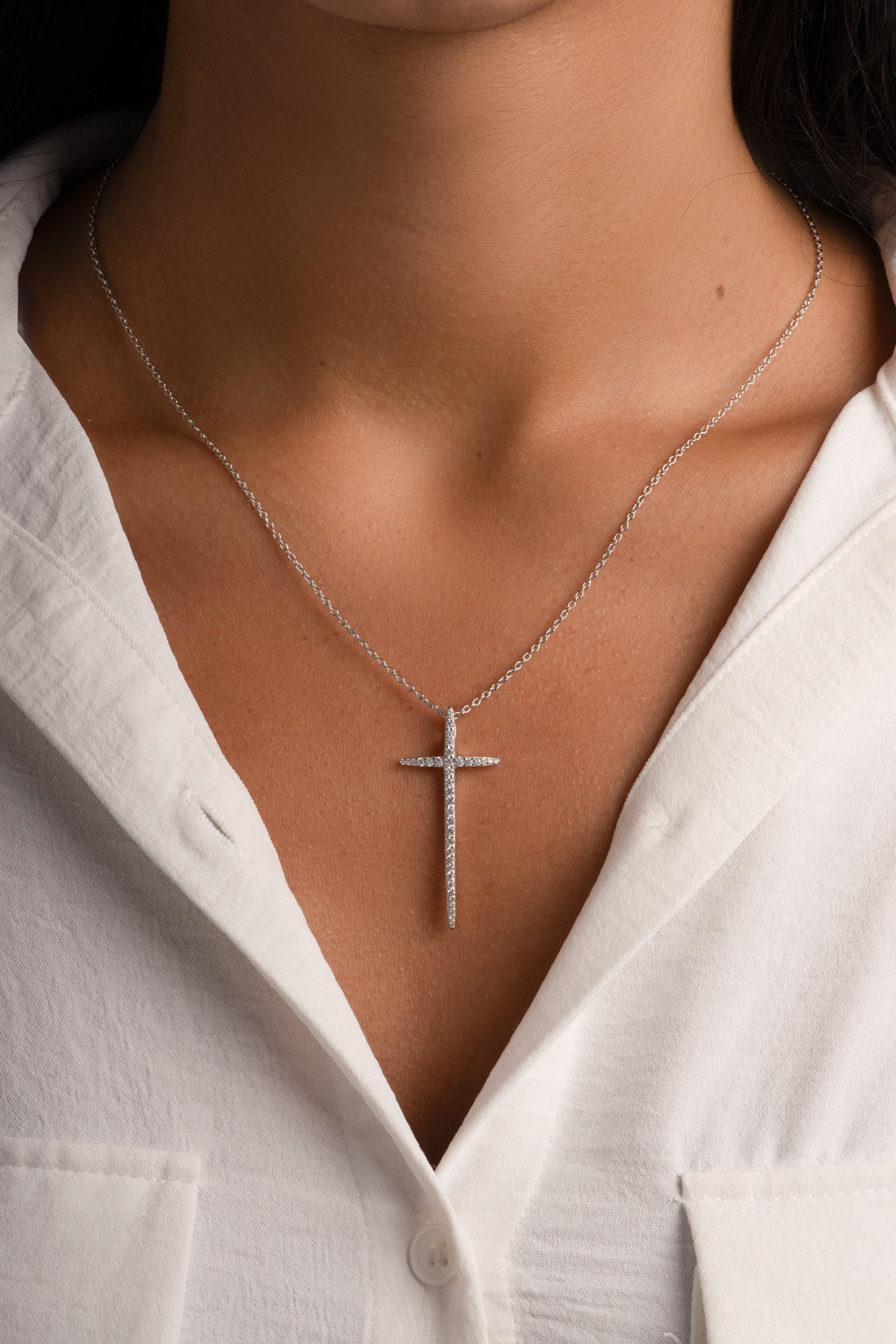 Sterling silver cross necklace by Sami Jewels, featuring a smooth, polished cross pendant on a delicate chain.