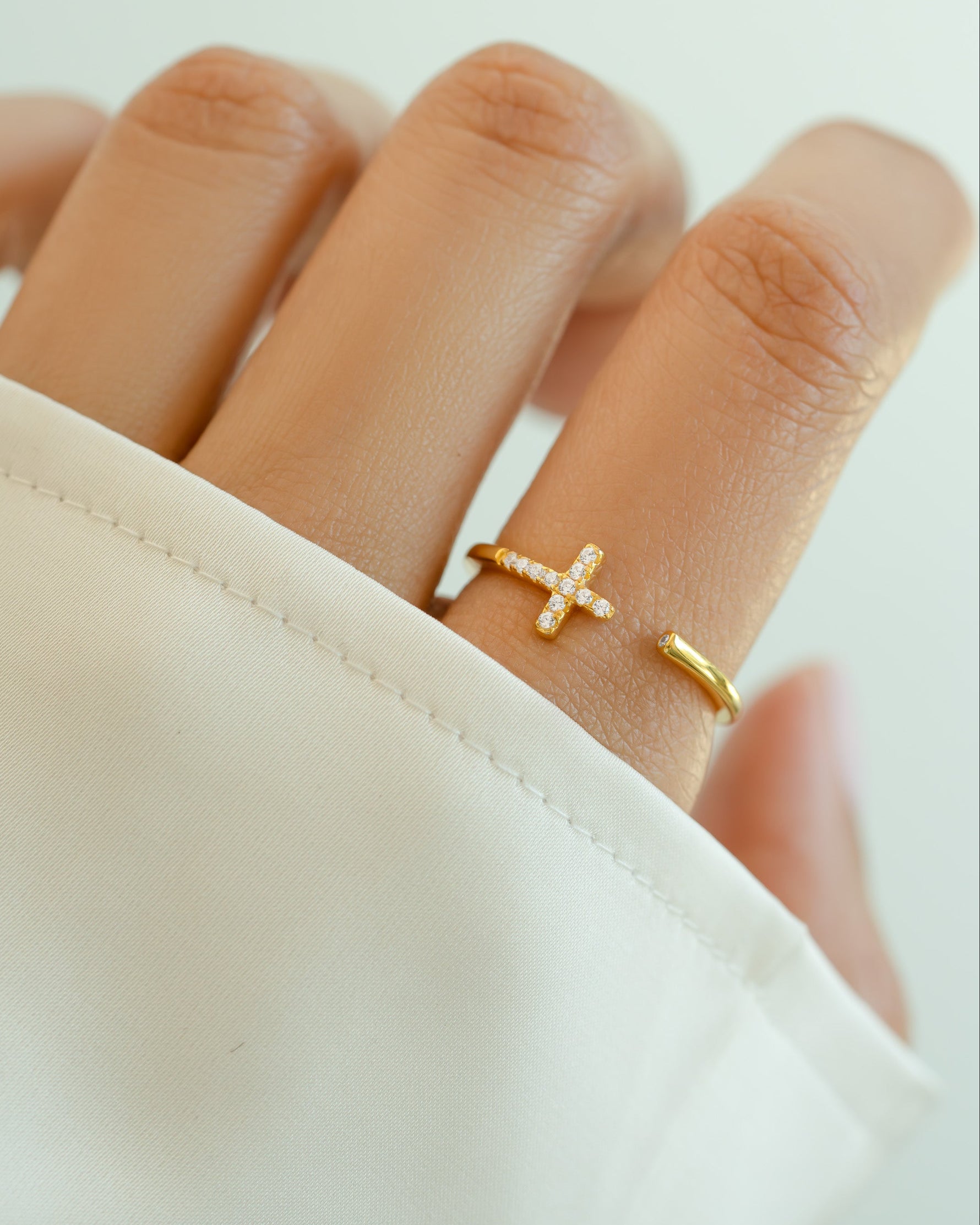 Gold cross open cuff ring by Sami Jewels featuring a stylish, minimalist design on a model's hand.