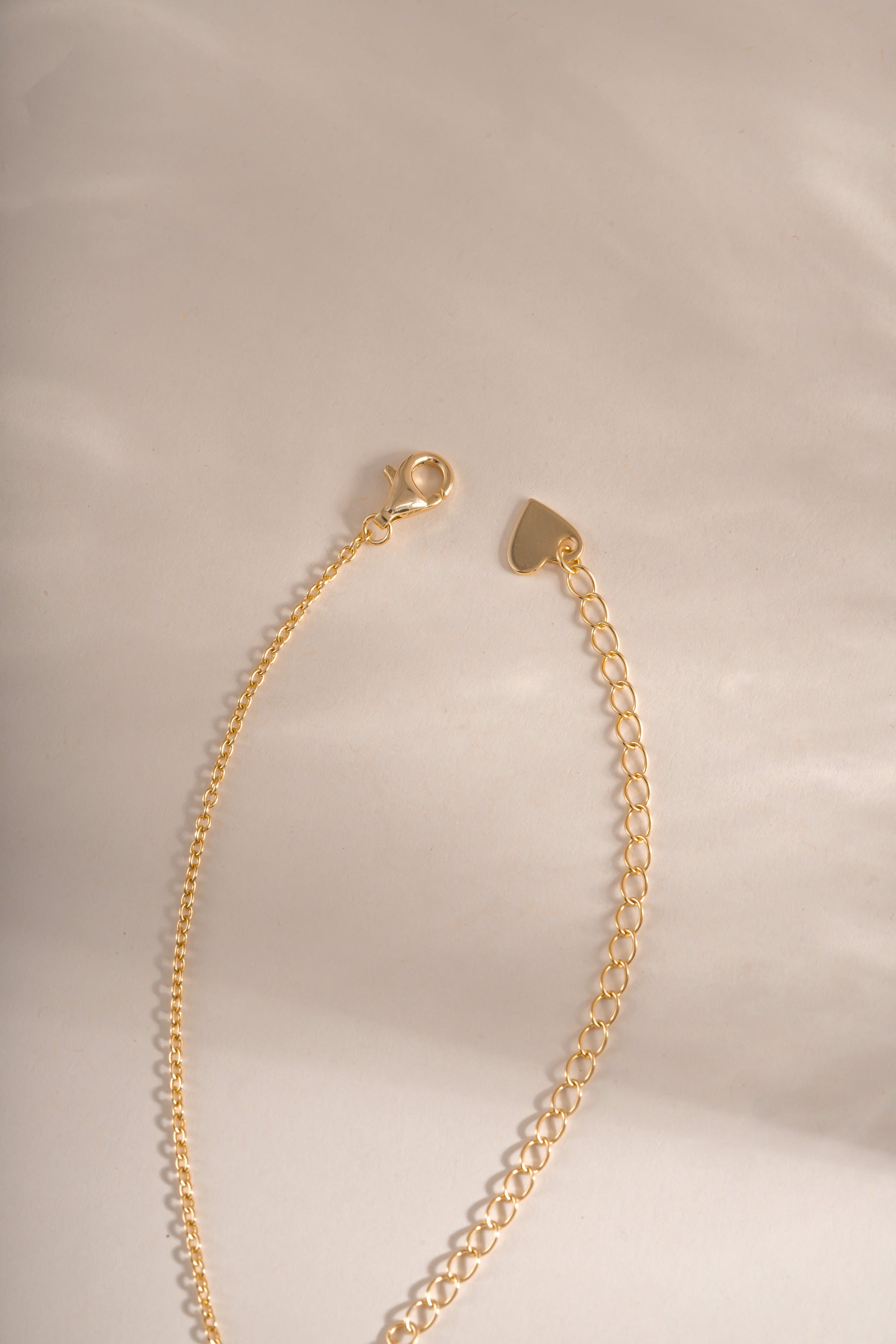 Gold cross pendant necklace with lobster clasp closure from Sami Jewels, featuring a sleek and elegant design.