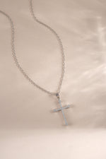 Sterling silver cross pendant necklace from Sami Jewels displayed flat, showcasing its sleek design and polished finish.