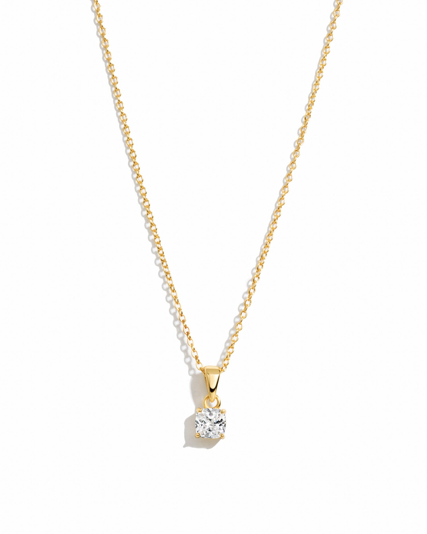 Gold cushion diamond pendant necklace by Sami Jewels displayed on a white background.