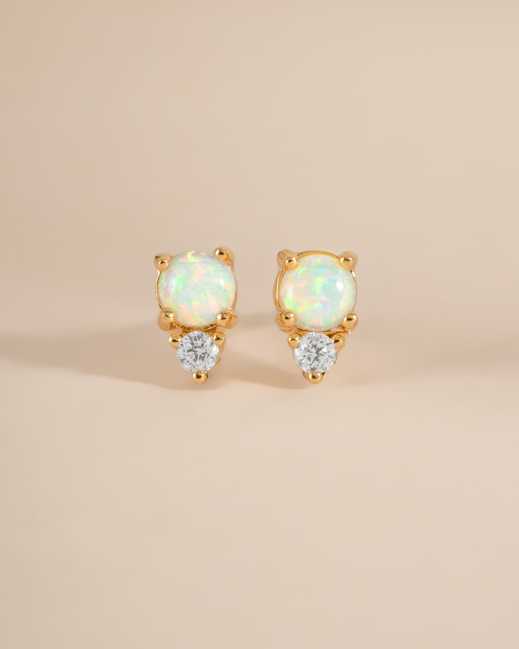 Close-up of gold opal and cubic zirconia stud earrings by Sami Jewels, showcasing their sparkling stones and elegant design.