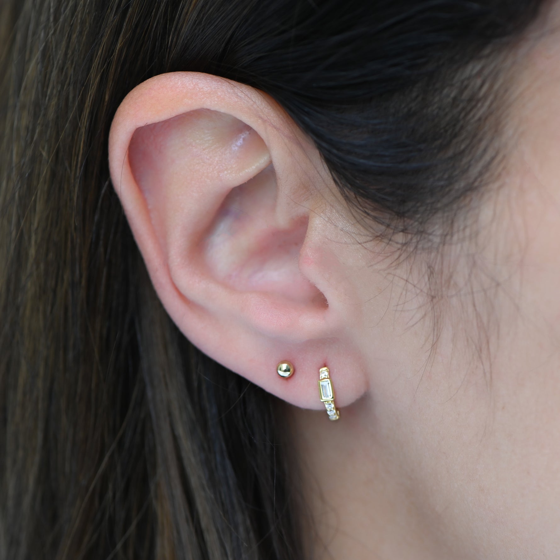 Gold CZ Baguette Huggie Earrings by Sami Jewels featuring sparkling rectangular stones and sleek hoop design.