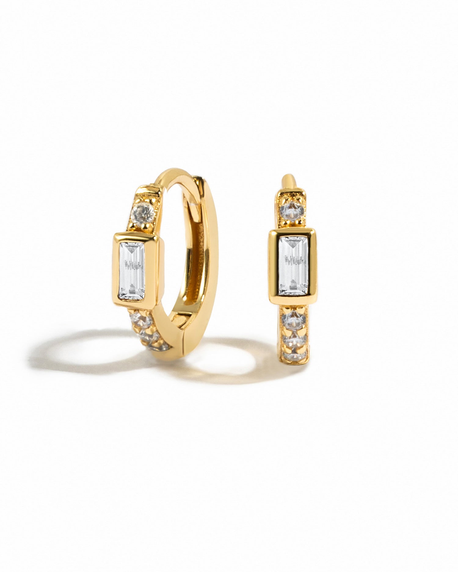 Gold baguette Huggie earrings by Sami Jewels, featuring sparkling cubic zirconia stones on a white background.