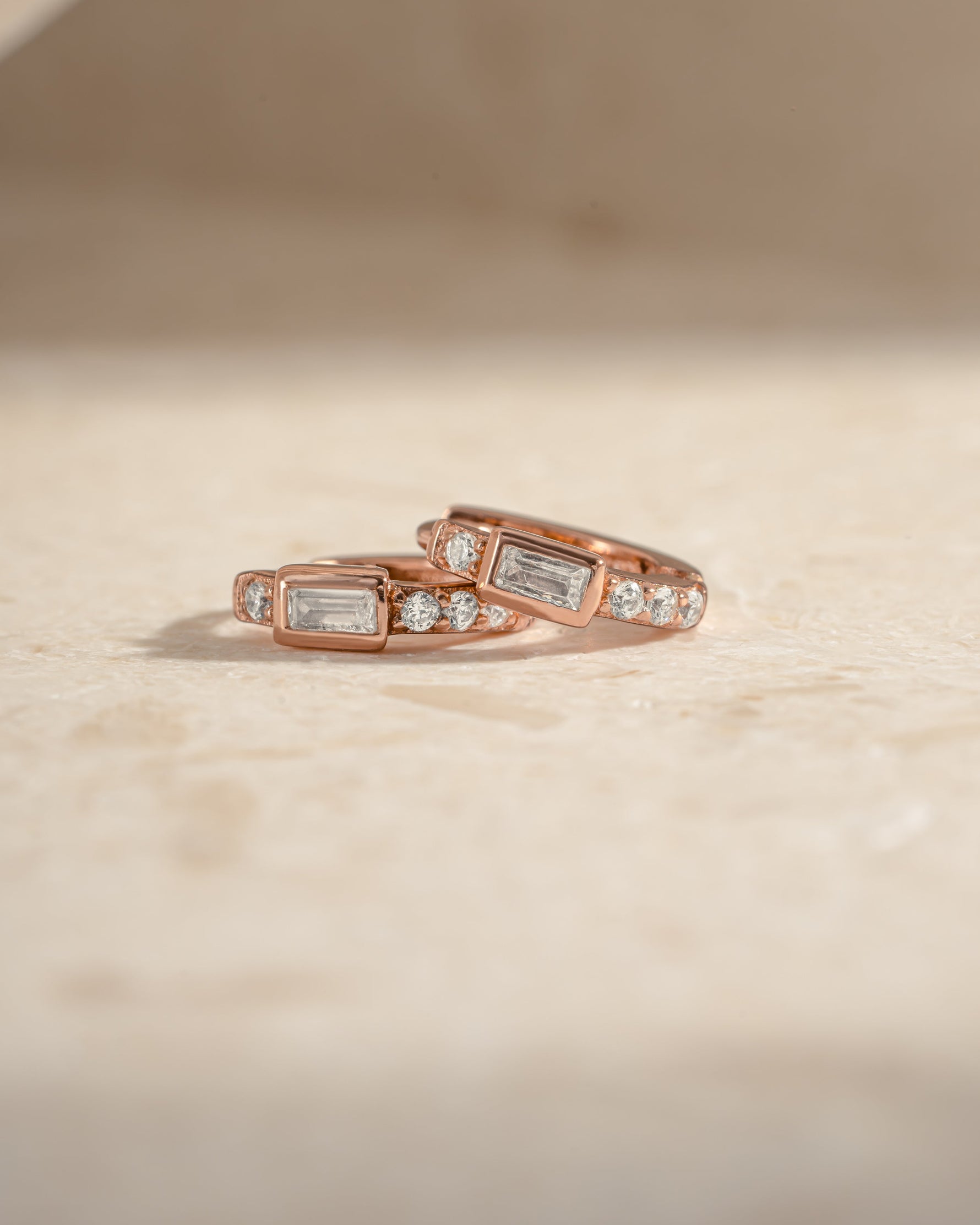 Rose gold CZ baguette huggie earrings by Sami Jewels, side view showcasing sleek design and sparkling stones.