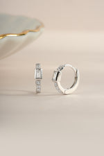 Sterling silver CZ baguette huggie earrings by Sami Jewels, featuring sparkling rectangular-cut cubic zirconia in a close-up view.