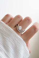 Model wearing a silver statement cz wedding ring set with oval diamond. 