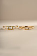 Up-close image of gold chevron ring set, showing both rings in the set, side by side. Left ring features 5 cz stones and right ring is plain gold. 