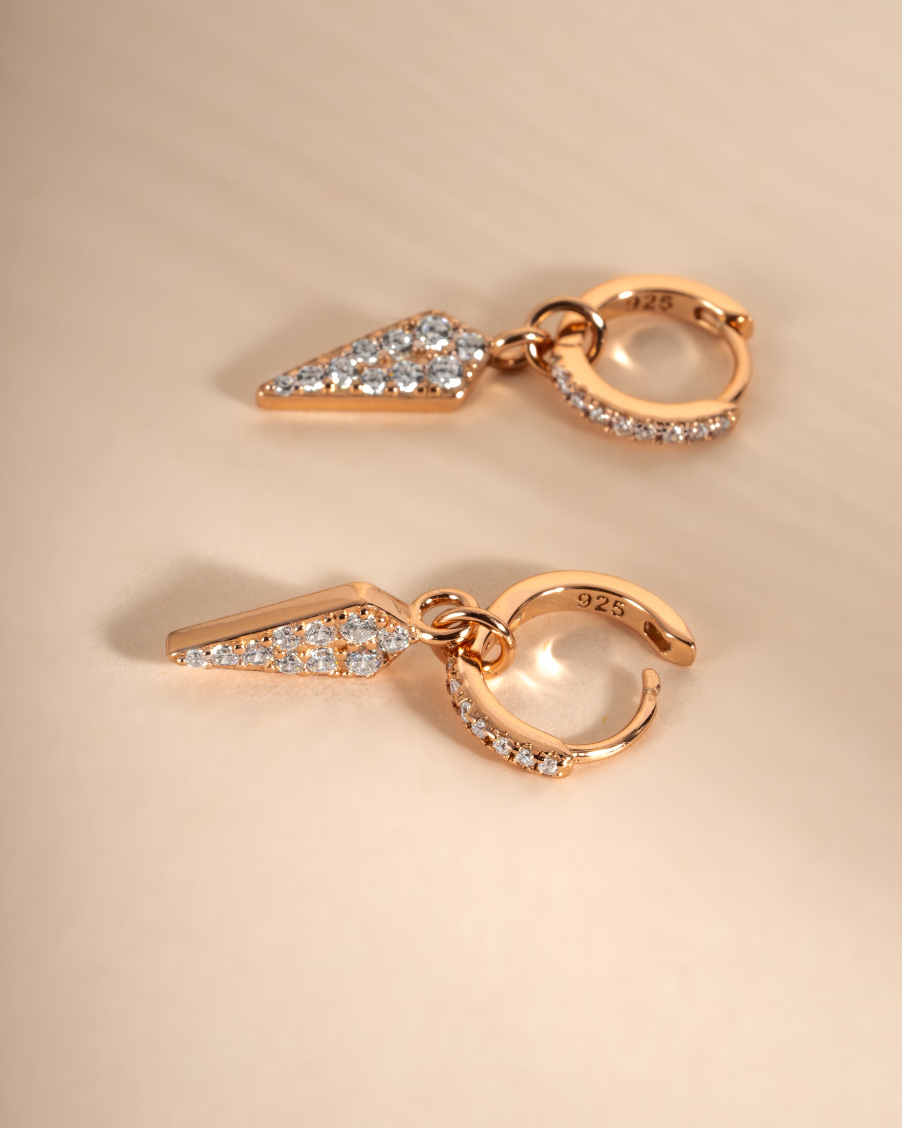 Gold Dagger Charm Huggies earrings by Sami Jewels featuring close-up view of small, stylish hoop earrings with dagger charms.
