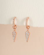 Rose gold Dagger Charm Huggie earrings by Sami Jewels, close-up view showing detailed dagger charms on small hoop earrings.