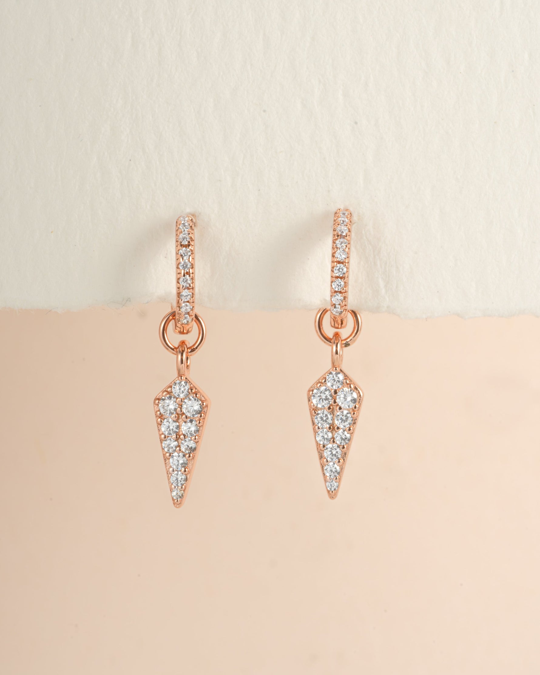Rose gold dagger charm huggie earrings by Sami Jewels, featuring small hoop earrings with dagger charms.