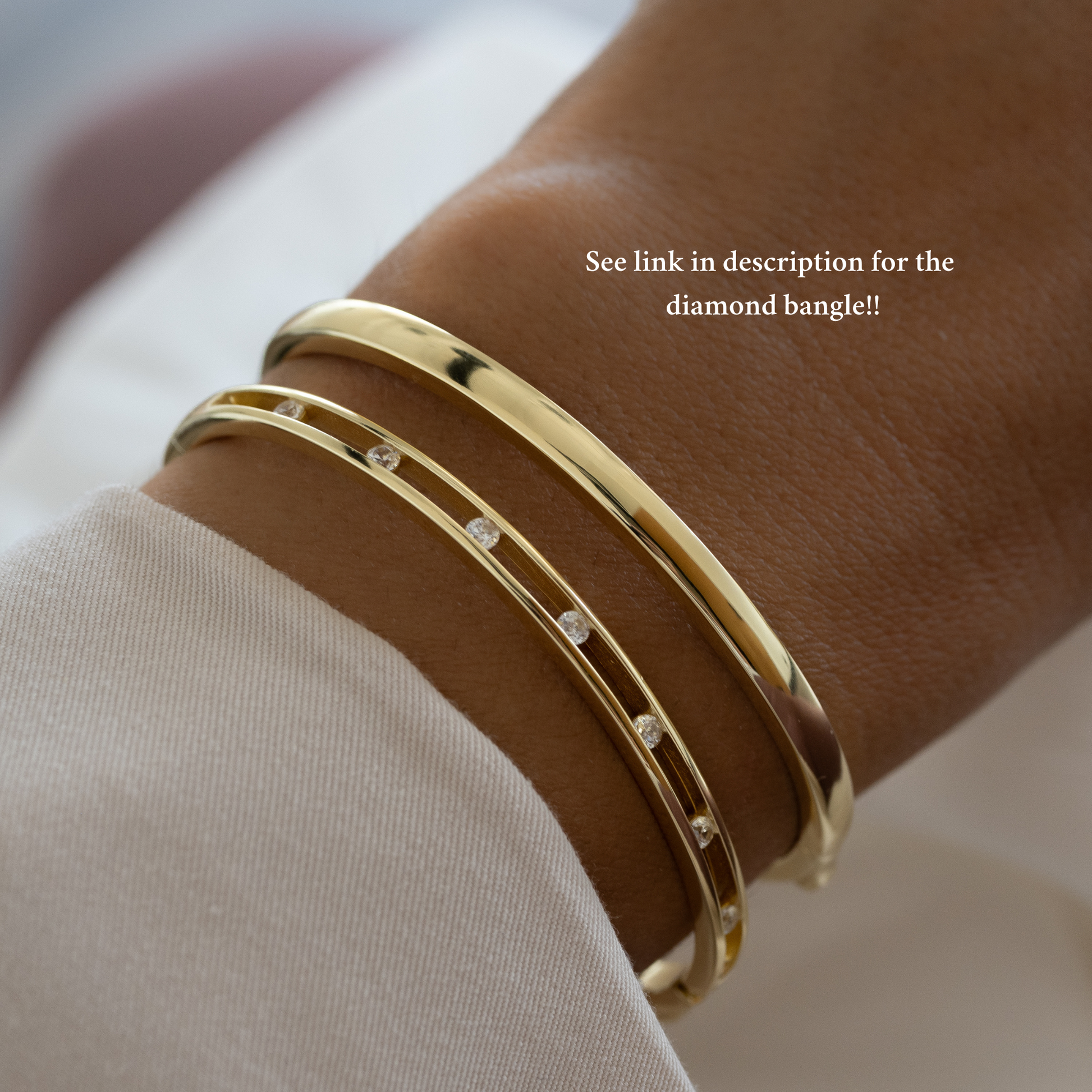 gold bangle with a studded diamond bangle on a wrist stacked together