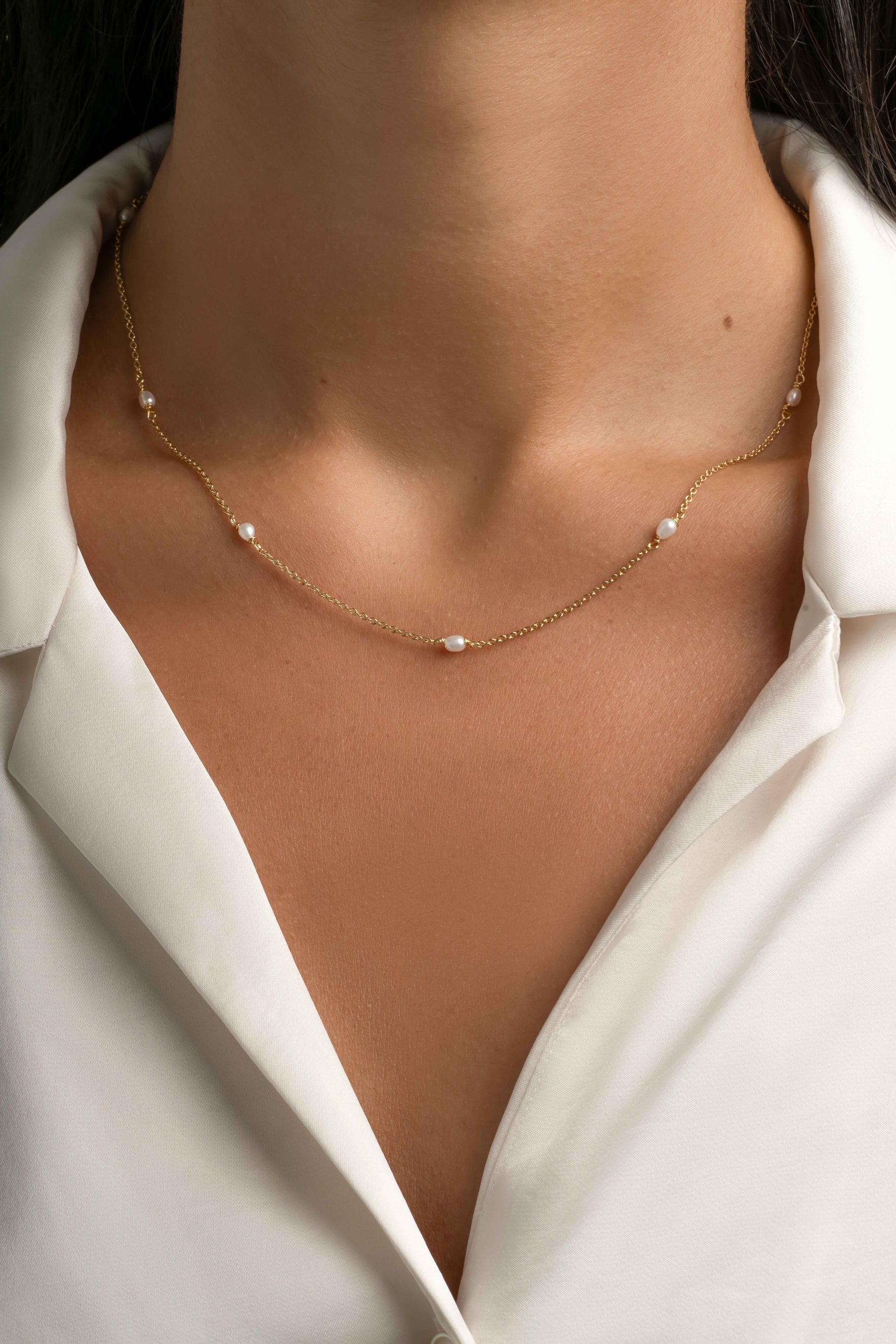 Gold beaded pearl necklace by Sami Jewels, featuring delicate pearl beads on a fine chain, worn by a model.
