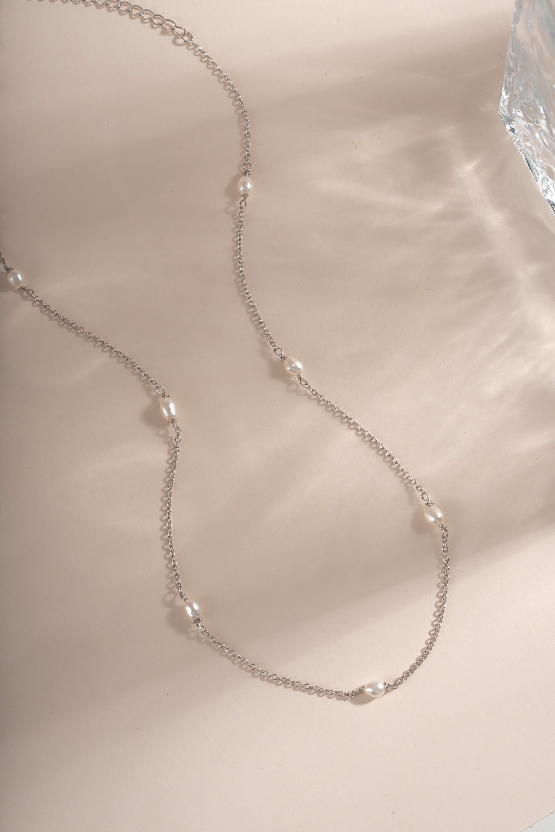 Dainty beaded pearl necklace by Sami Jewels featuring small pearls on a sterling silver chain, displayed flat.