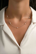 Dainty beaded pearl necklace by Sami Jewels featuring small pearls on a sterling silver chain, worn by a model.