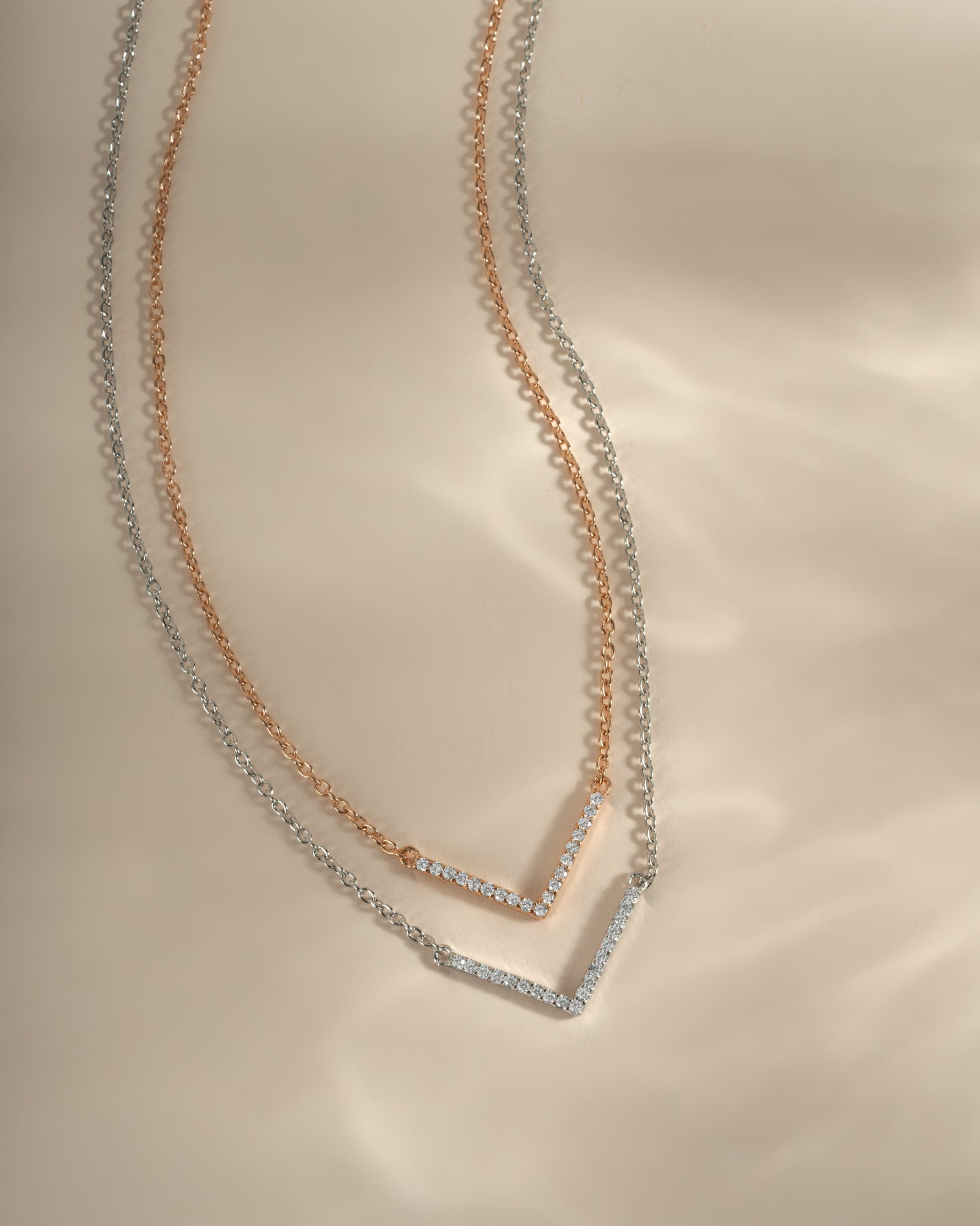 Dainty rose gold and sterling silver chevron necklace from Sami Jewels, featuring a sleek V-shaped pendant on a delicate chain.