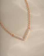 Close-up of Sami Jewels rose gold chevron necklace, showcasing its dainty and elegant design on a white background.