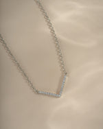 Close-up of a sterling silver chevron necklace from Sami Jewels, showcasing a delicate, dainty pendant on a fine chain.