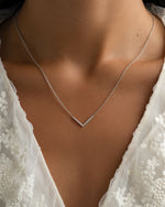 Dainty sterling silver Chevron necklace from Sami Jewels displayed on a model. Elegant jewelry accessory featuring a sleek chevron design.