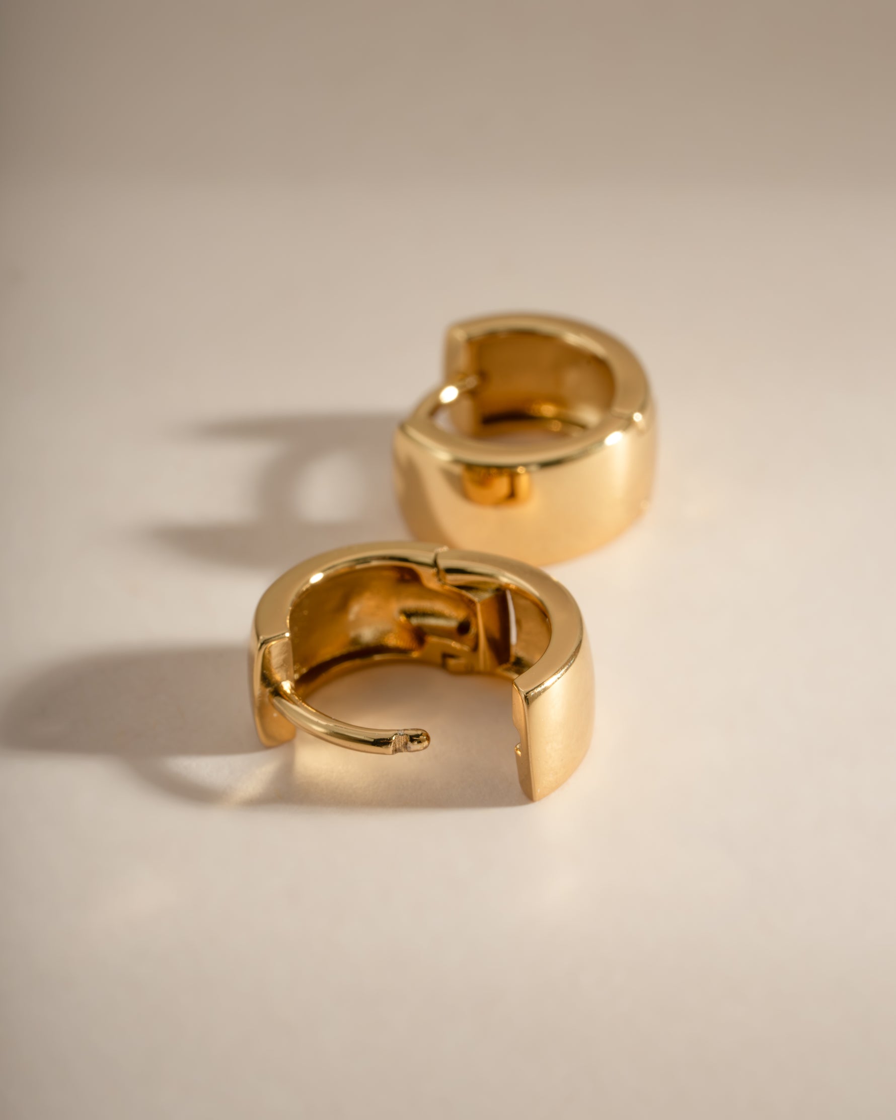 Close-up of small gold chunky hoop earrings by Sami Jewels, showcasing their dainty, textured design.