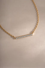Close-up of Sami Jewels dainty gold bar necklace with a small diamond, showcasing a delicate and elegant jewelry piece.