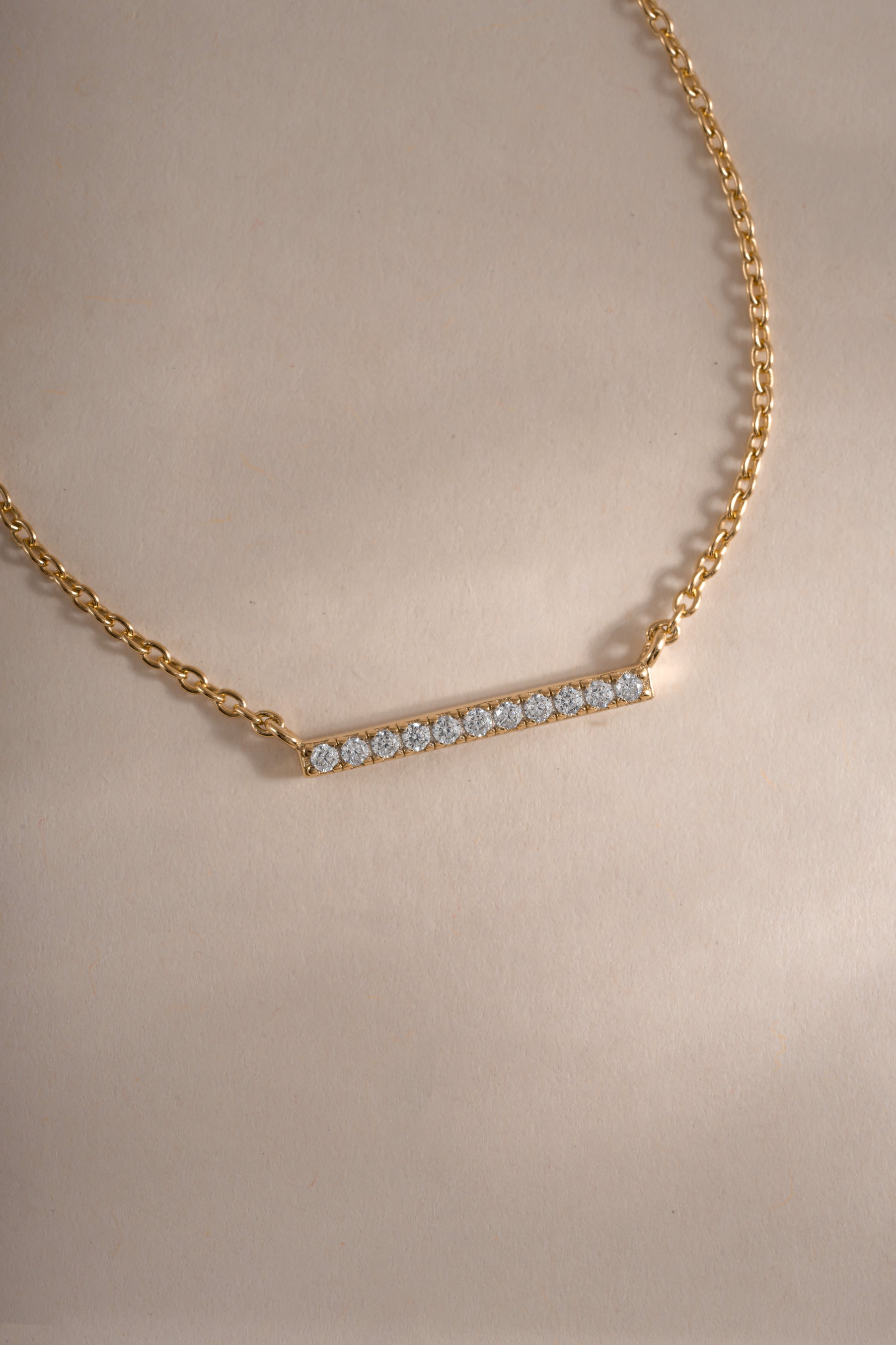 Close-up of Sami Jewels dainty gold bar necklace with a small diamond, showcasing a delicate and elegant jewelry piece.