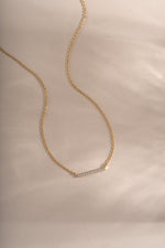 Gold dainty bar necklace from Sami Jewels featuring a slim diamond-studded bar pendant on a delicate chain.