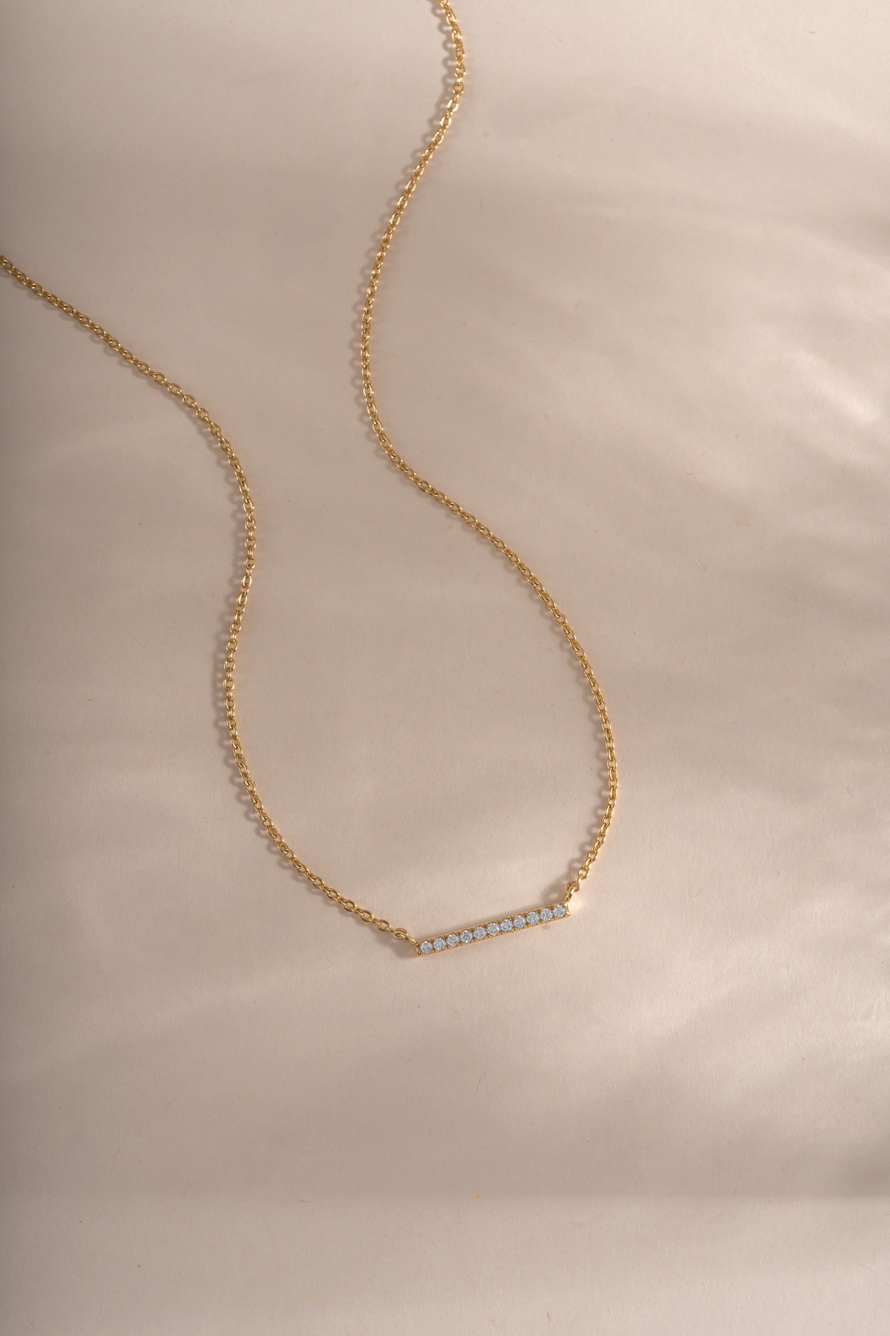 Gold dainty bar necklace from Sami Jewels featuring a slim diamond-studded bar pendant on a delicate chain.