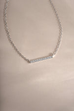 Close-up of Sami Jewels dainty sterling silver bar necklace with small diamond accent, showcasing elegant minimalist jewelry design.
