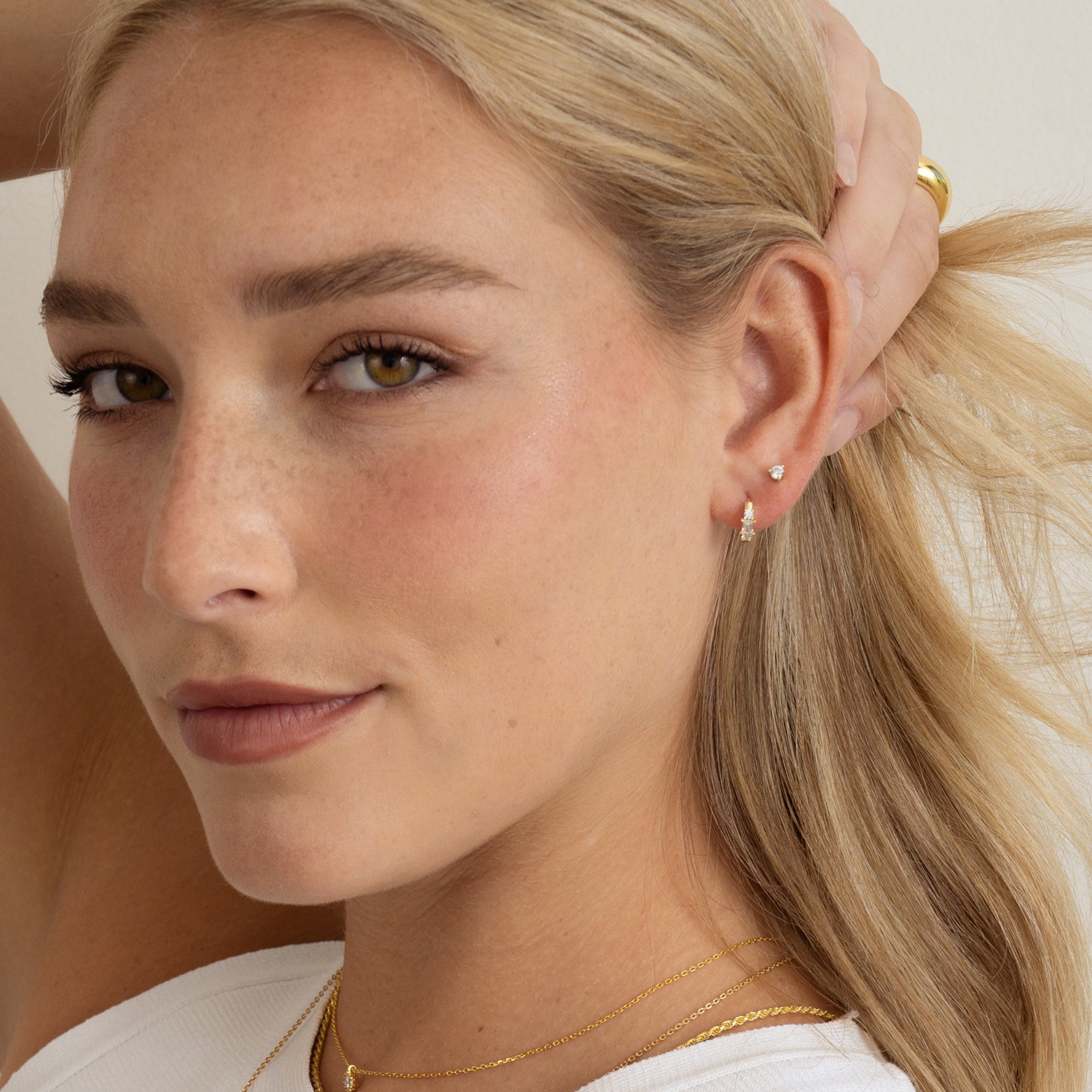 Model wearing dainty diamond earrings