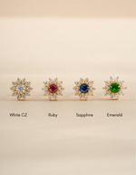 Gold flower earrings with small gemstones from Sami Jewels, featuring delicate petal designs and vibrant colored stones.