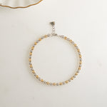 Flat lay of a mixed metal jewelry with beads and diamonds.