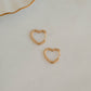 Dainty gold earrings with heart design, gift for her, shown on white marble background