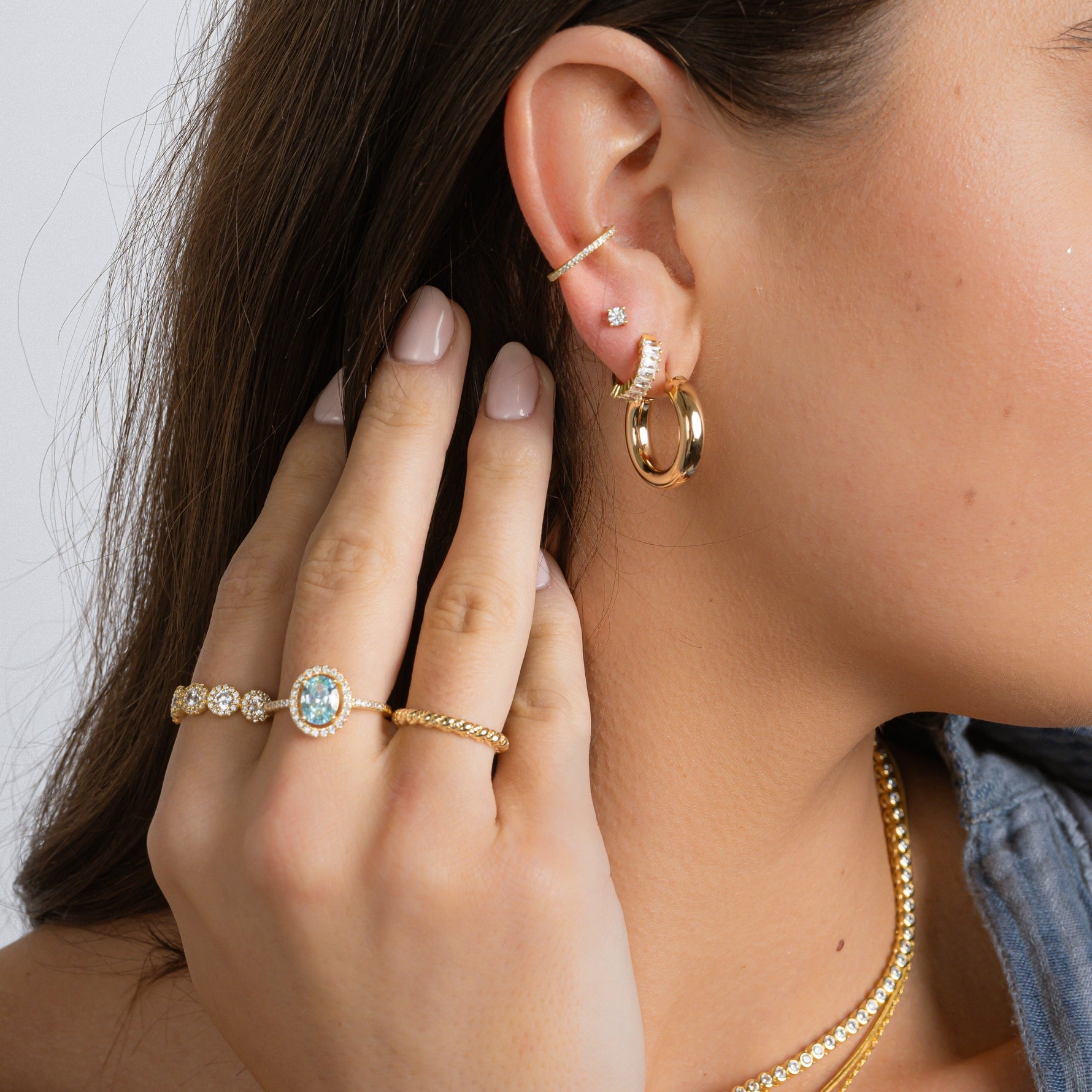 A model adorned with a 14K gold rings and earrings, the delicate texture gliding effortlessly against her skin. 