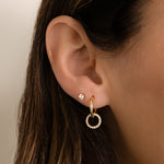 model wearing Gold hoop earrings with pavé charm, styled in a curated ear stack for a modern and minimalist esthetic. 