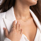 Woman wearing a gold moissanite diamond necklace with dainty, fine chain.