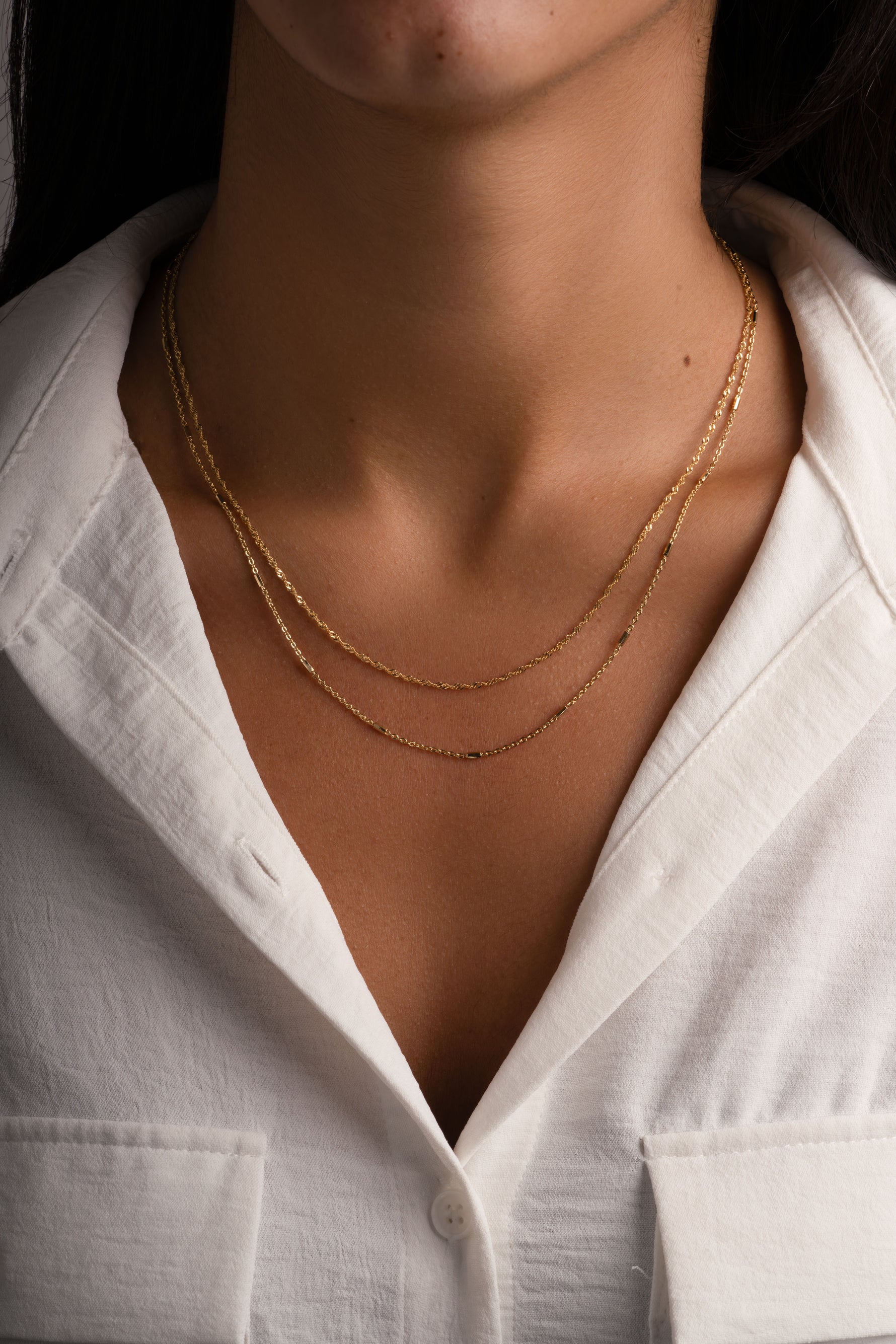 Dainty gold layering necklace set from Sami Jewels displayed on a model, featuring multiple thin chain necklaces for a stylish layered look.