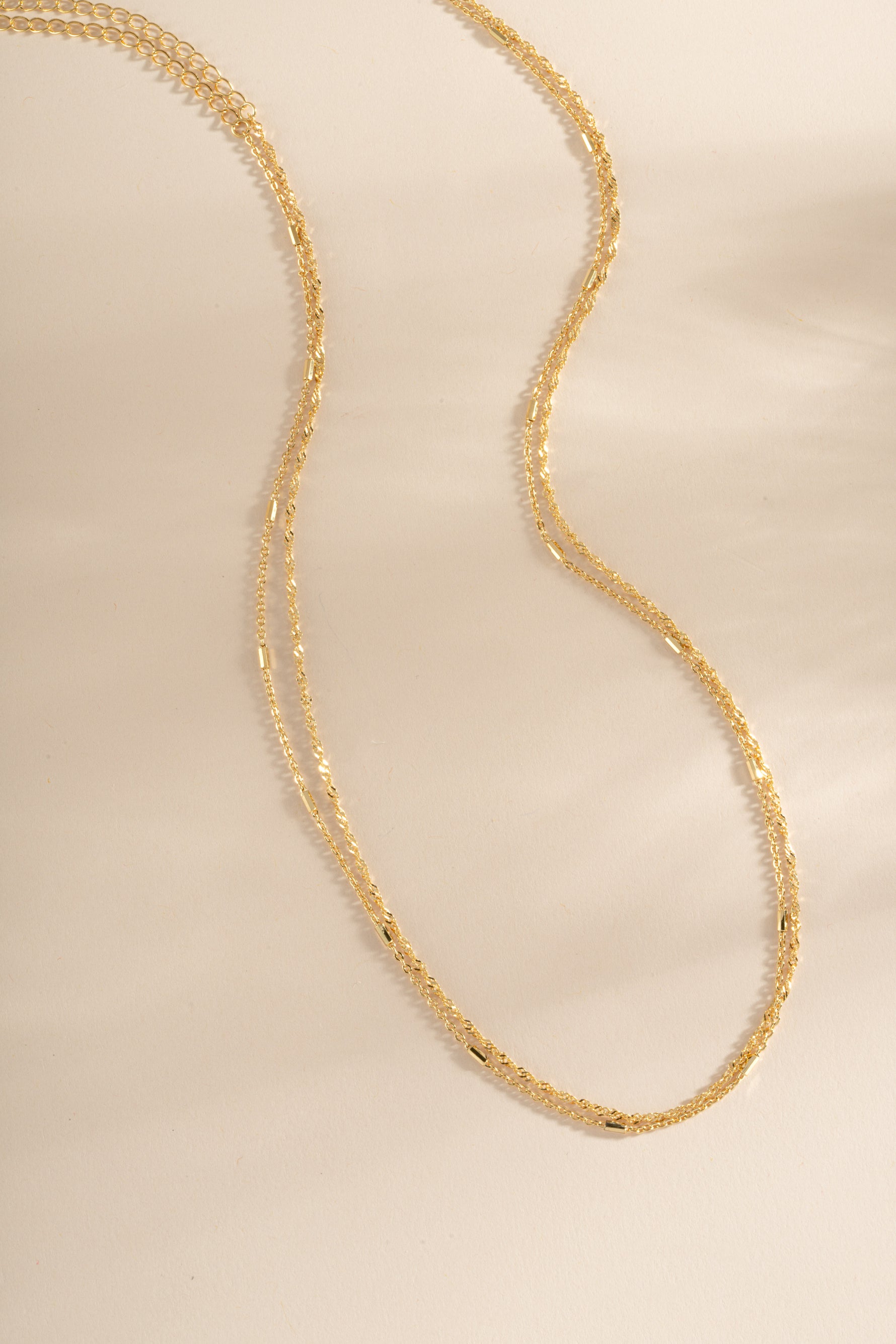 Dainty gold layering necklace set by Sami Jewels featuring multiple delicate chain necklaces on a white background.